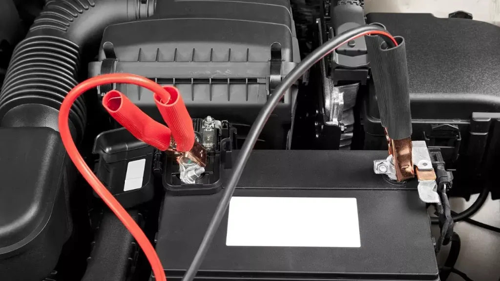 Car battery with jumper cables connected for jump-starting